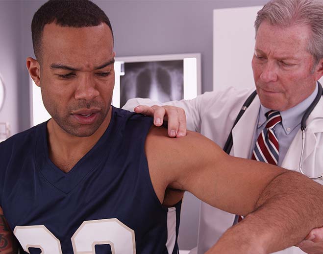 man being treated by sports medicine doctor